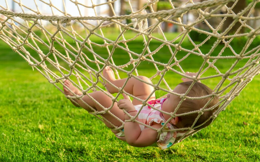 Baby is lying on a hammock. Selective focus.